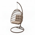 Load image into Gallery viewer, Brown hanging chair with beige cushion on a concrete floor.