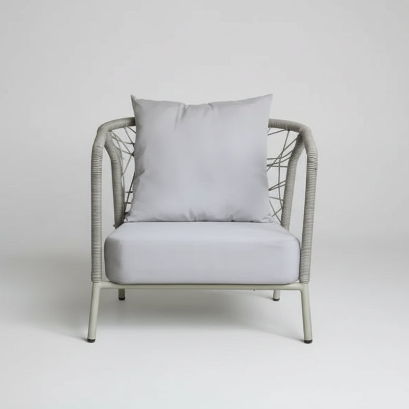 Gray armchair with a pillow in a room with fabric samples on the wall.