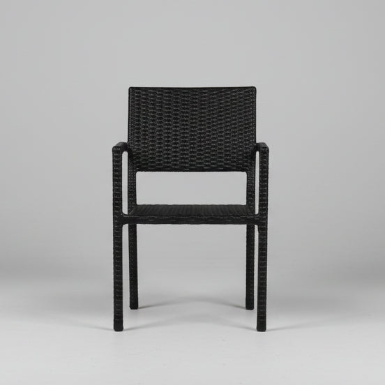 Black wicker chair in a room with white walls and gray floor.