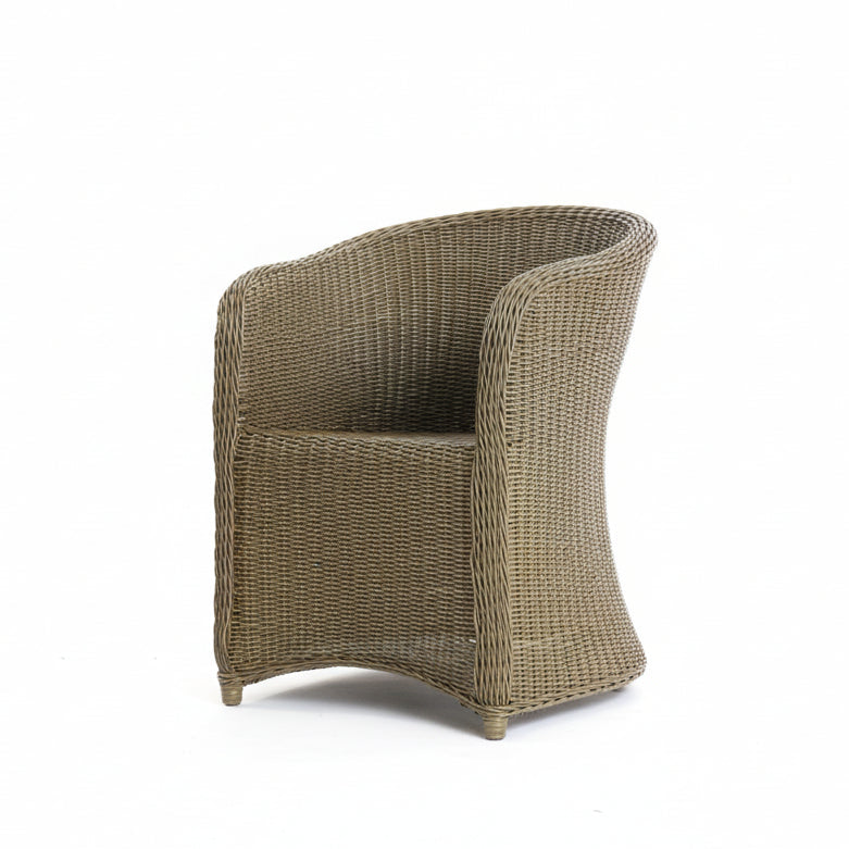 Wicker chair in a room with white walls and a concrete floor.