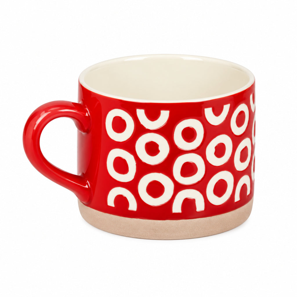 A red ceramic mug with a cream-colored interior and a repeating pattern of white semi-circles on the exterior, set against a plain light gray background.