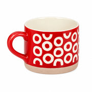 A red ceramic mug with a cream-colored interior and a repeating pattern of white semi-circles on the exterior, set against a plain light gray background.