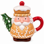 Load image into Gallery viewer, A ceramic Santa Claus holiday teapot shaped like a gingerbread man, with a cupcake lid, red handle, and green Christmas tree spout, resting on bubble wrap in front of a computer monitor.

